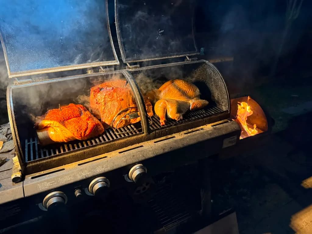 Seasoned meats and poultry smoking over the grill